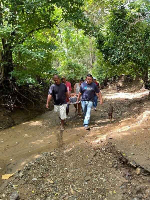 Team carrying patient through riverbed