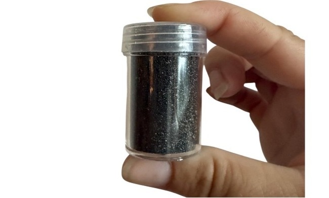 Tiny vial of black sand